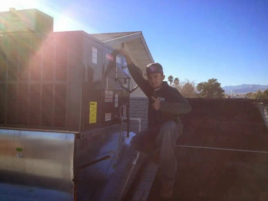 HVAC technician performing Boiler Repair on a rooftop unit in Williamsburg